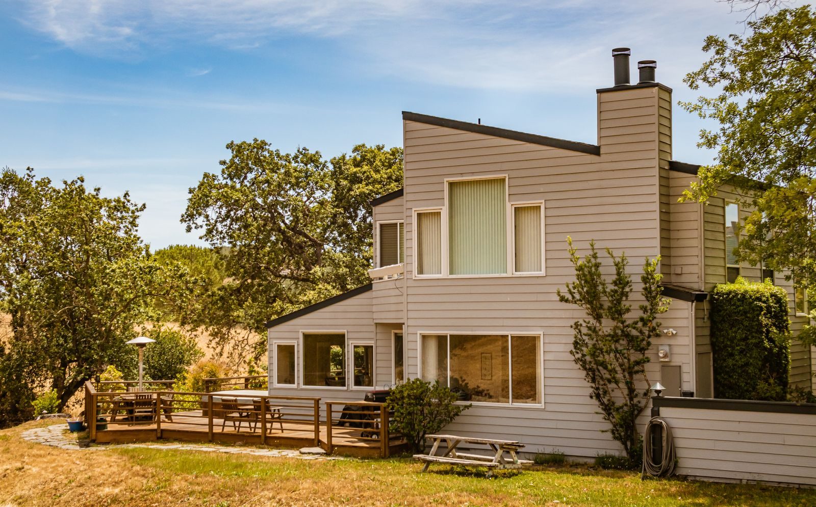 Home with a wooden backyard deck and fenced garden