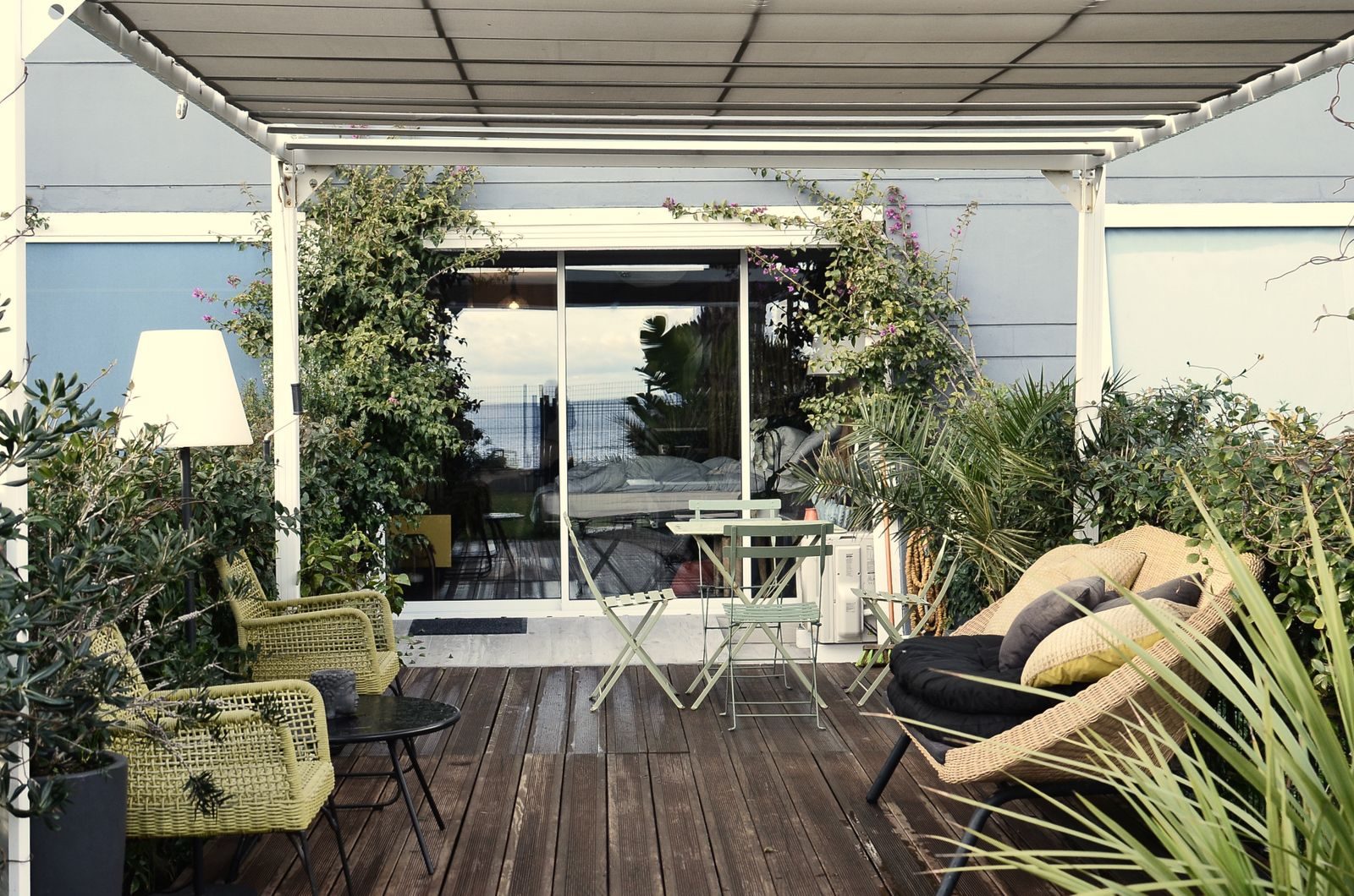 Wooden deck with pergola and outdoor seating beside a home
